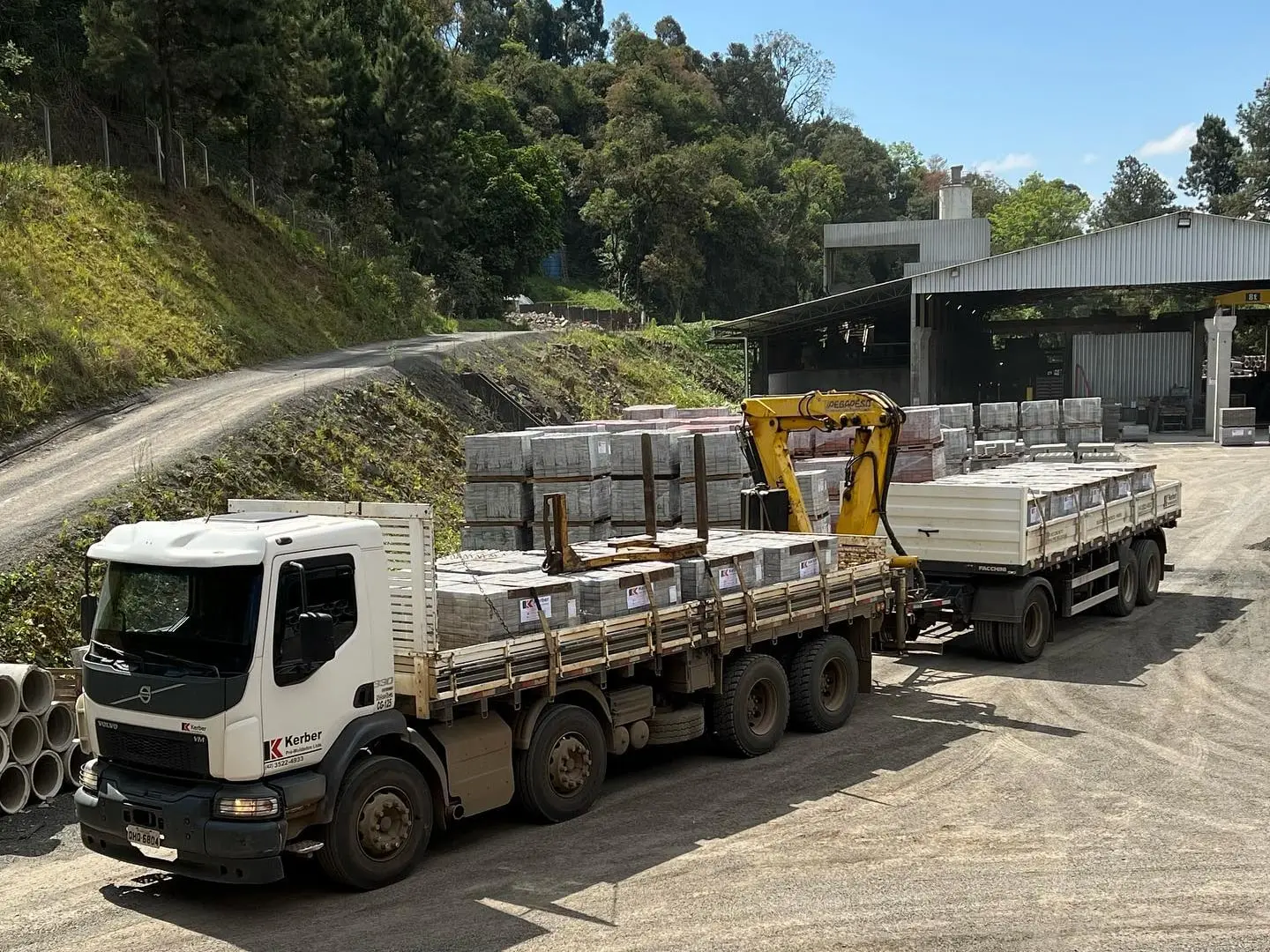 Caminhão da Kerber carregado de paletes de pavers no pátio da fábrica