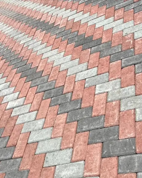 Pavers vermelhos, cinza e grafite assentados em espinha de peixe.